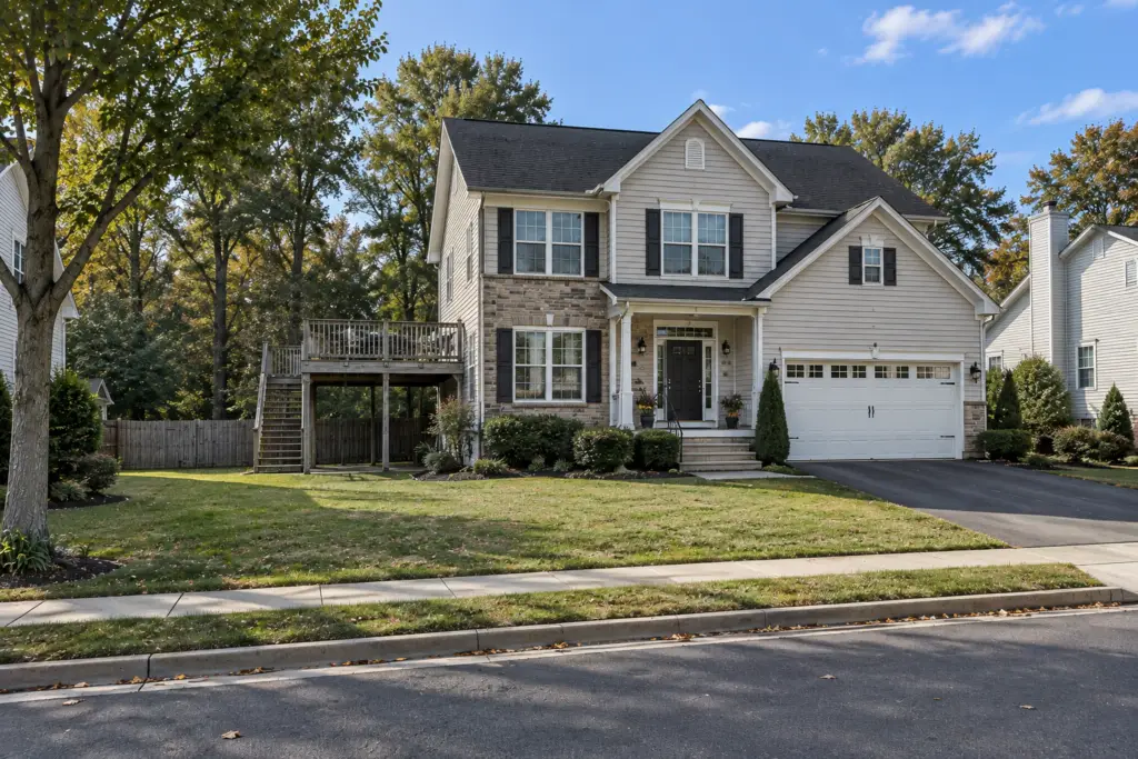 Before composite deck builder project in Fairland, MD showing an aging raised wood deck and complete suburban home