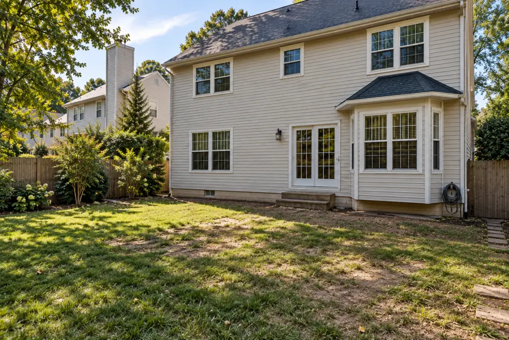 Before composite deck builder project in Glenmont, MD showing a backyard without a deck and an existing residential home